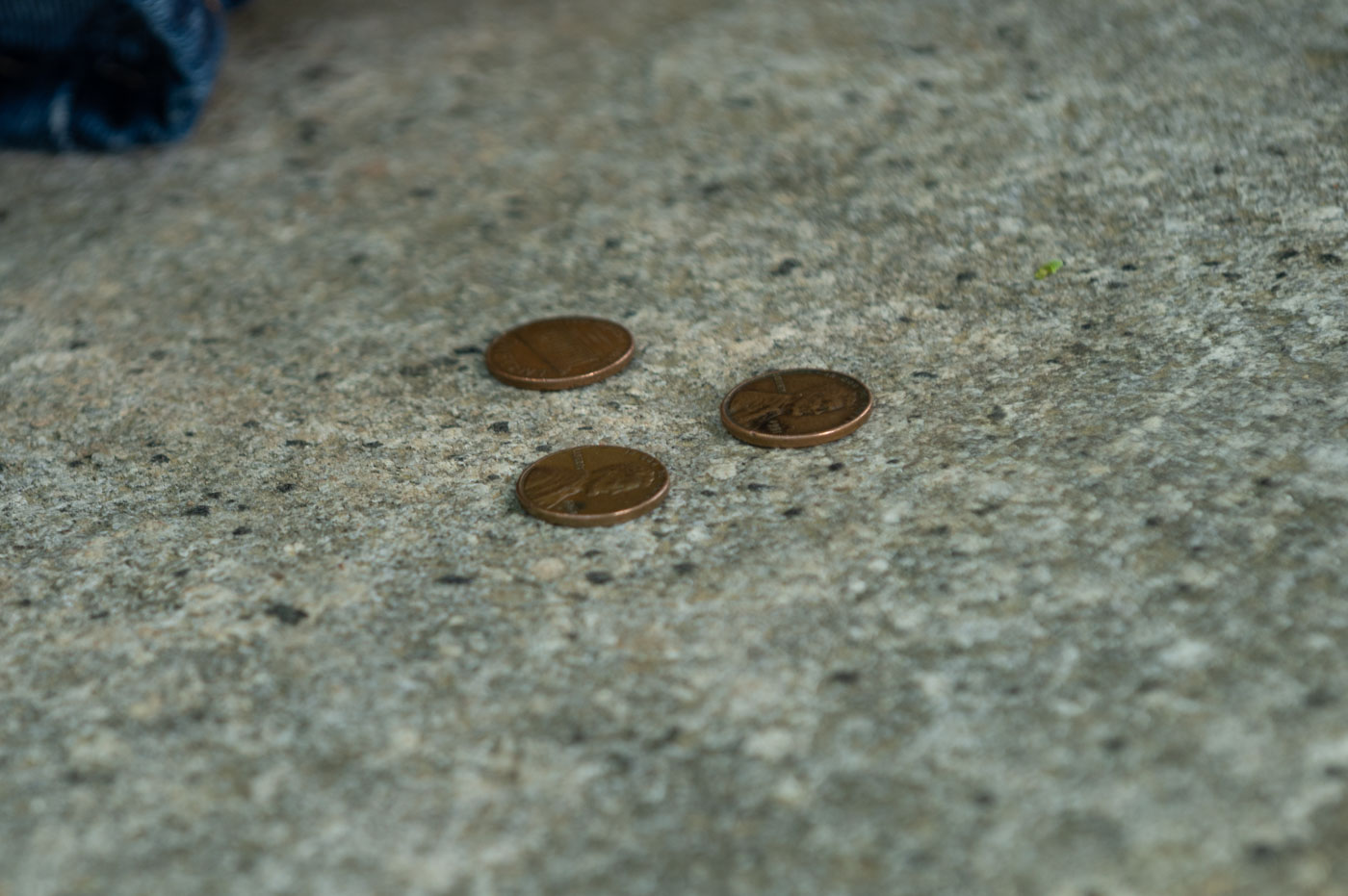 Three copper I Ching coins cast on a slab of granite
